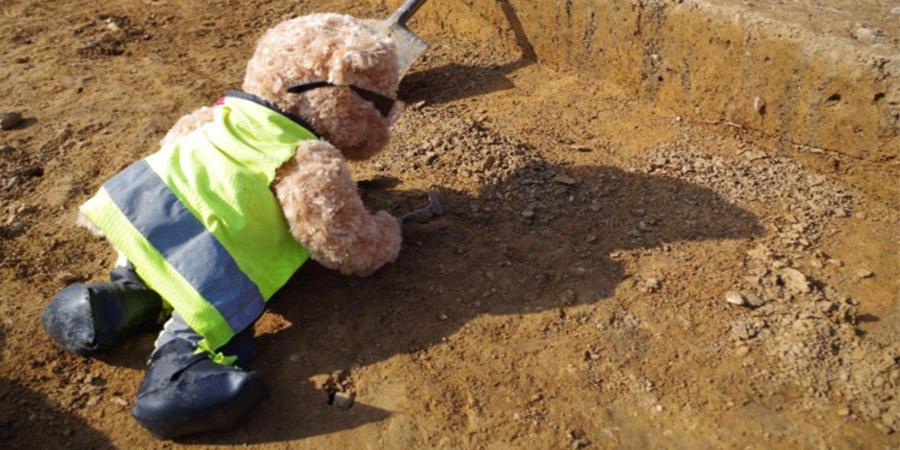 Kent Jones bear archaeologist excavating on site in summer