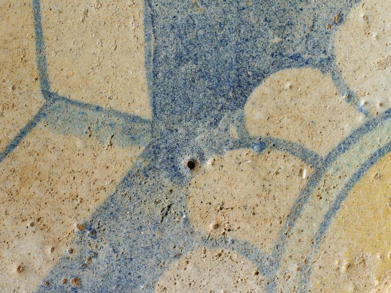 Glazed medieval tile with flower motif