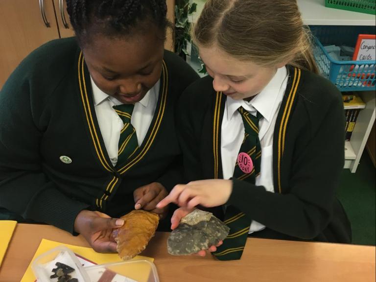 Pupils from St James' C of E Primary School studying a palaeolithic handaxe and a replica