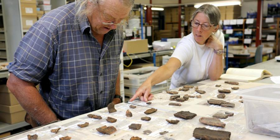 Phil Harding being shown pottery mould fragments in the finds room