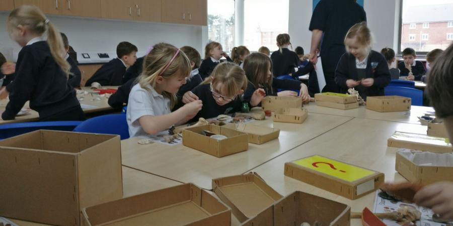 Pupils at Old Sarum Primary School examining artefacts
