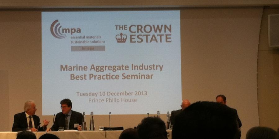 dark conference room with two men in suits in conversation 