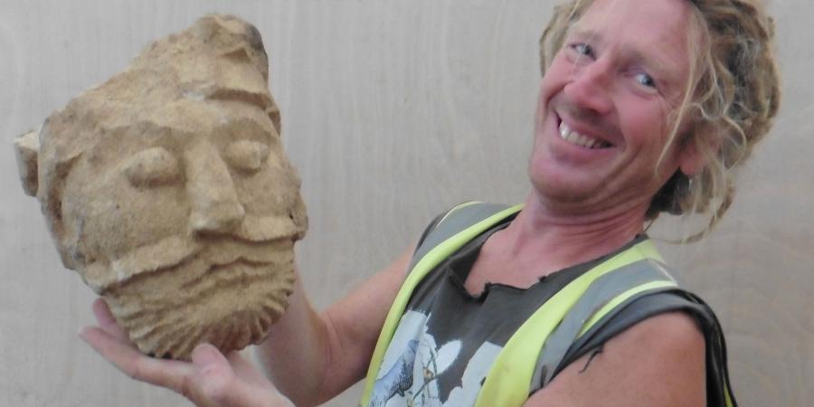 Archaeologist Lee Newton with the carved head