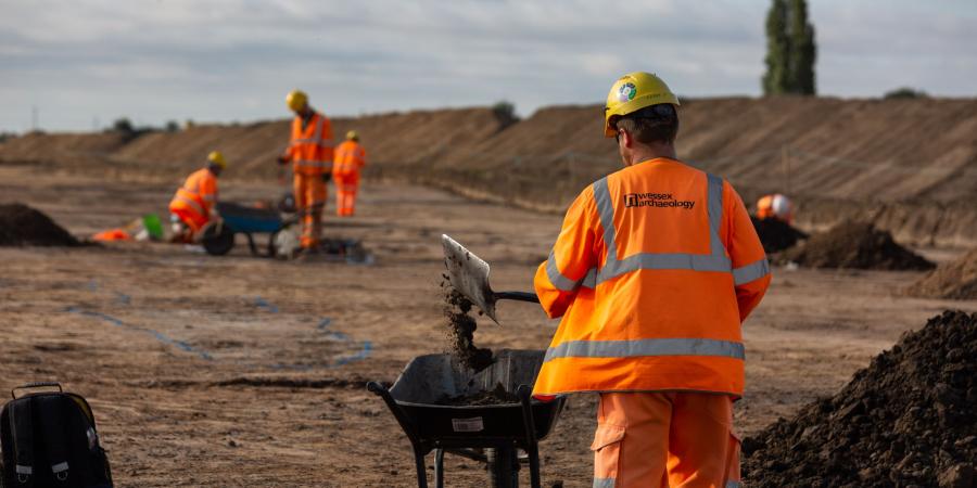 Viking Link Interconnector Archaeological work shows a large stripped area with archaeologist in hi vis and mounds of soil