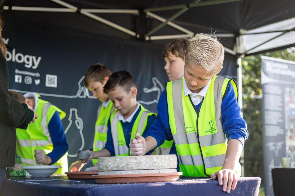 A child uses a replica quern