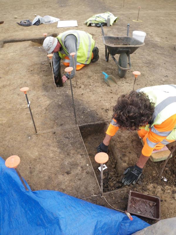 archaeologists working on excavation slots along the foundation ditch