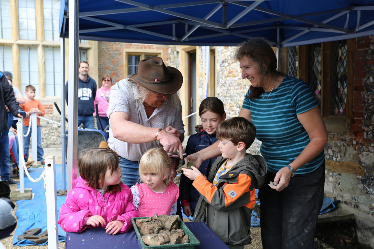 Children look at archaeological finds with Phil Harding