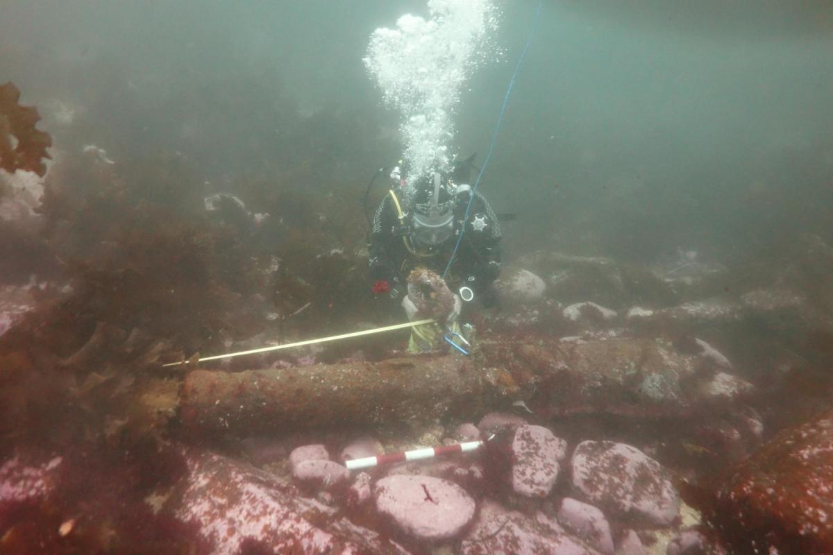 Diver measuring a cannon for Historic Environment Scotland