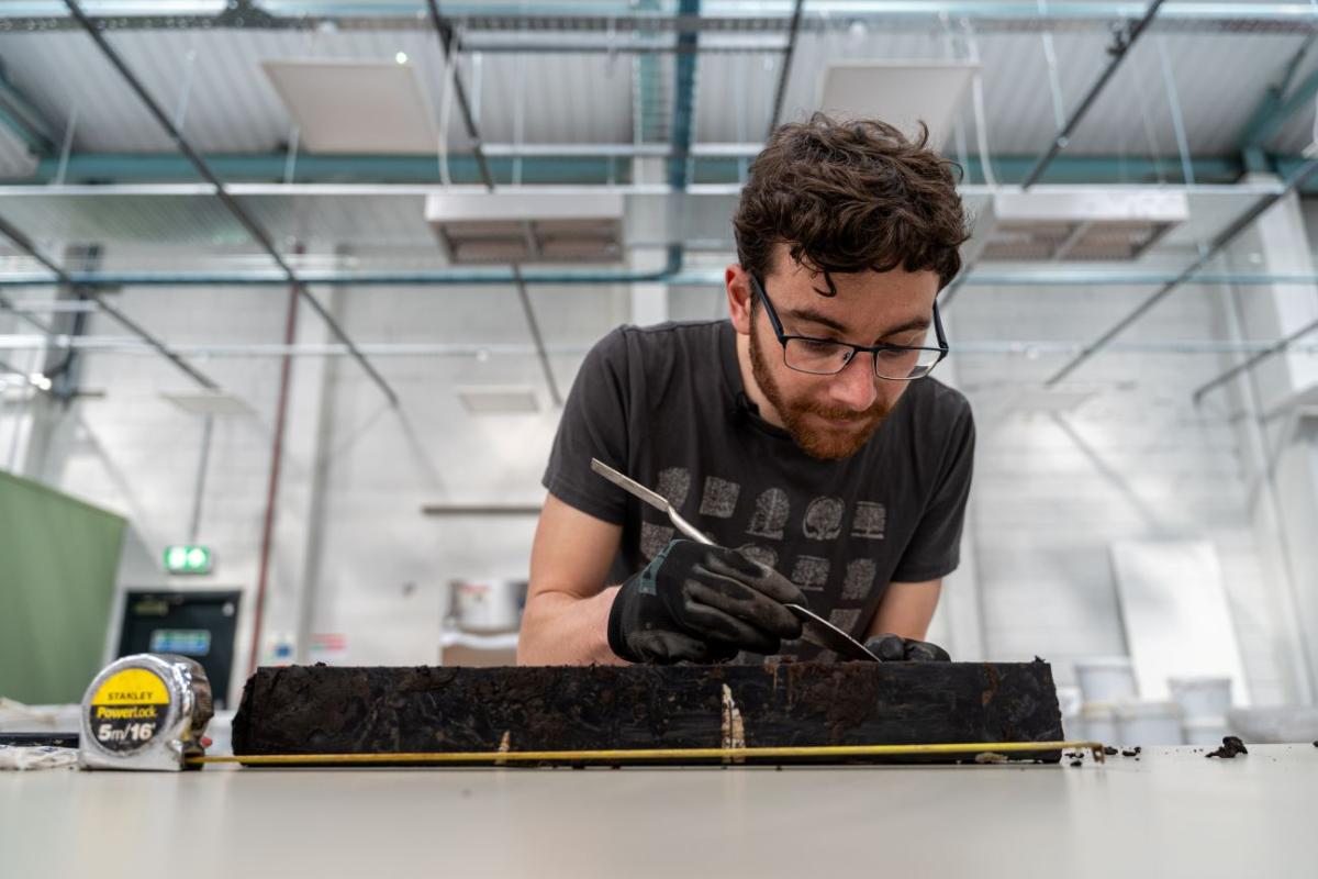 He has placed the sample next to a measuring tape.