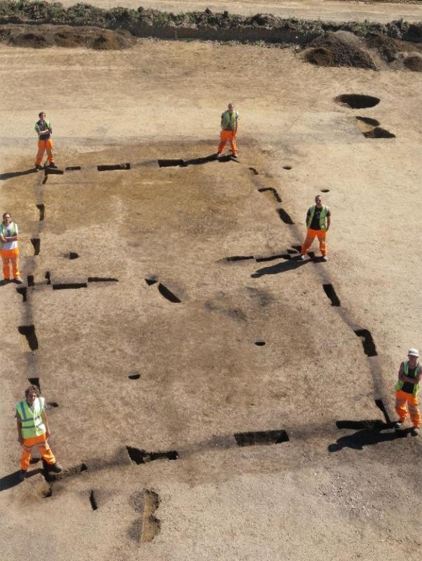 archaeologists excavation team standing around the foundation ditch of the house