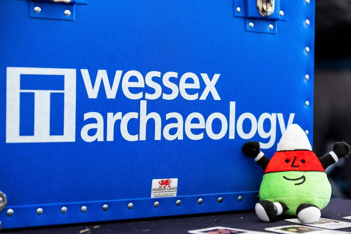 Eisteddfor yr Urdd mascot in front of Wessex Archaeology loan box 