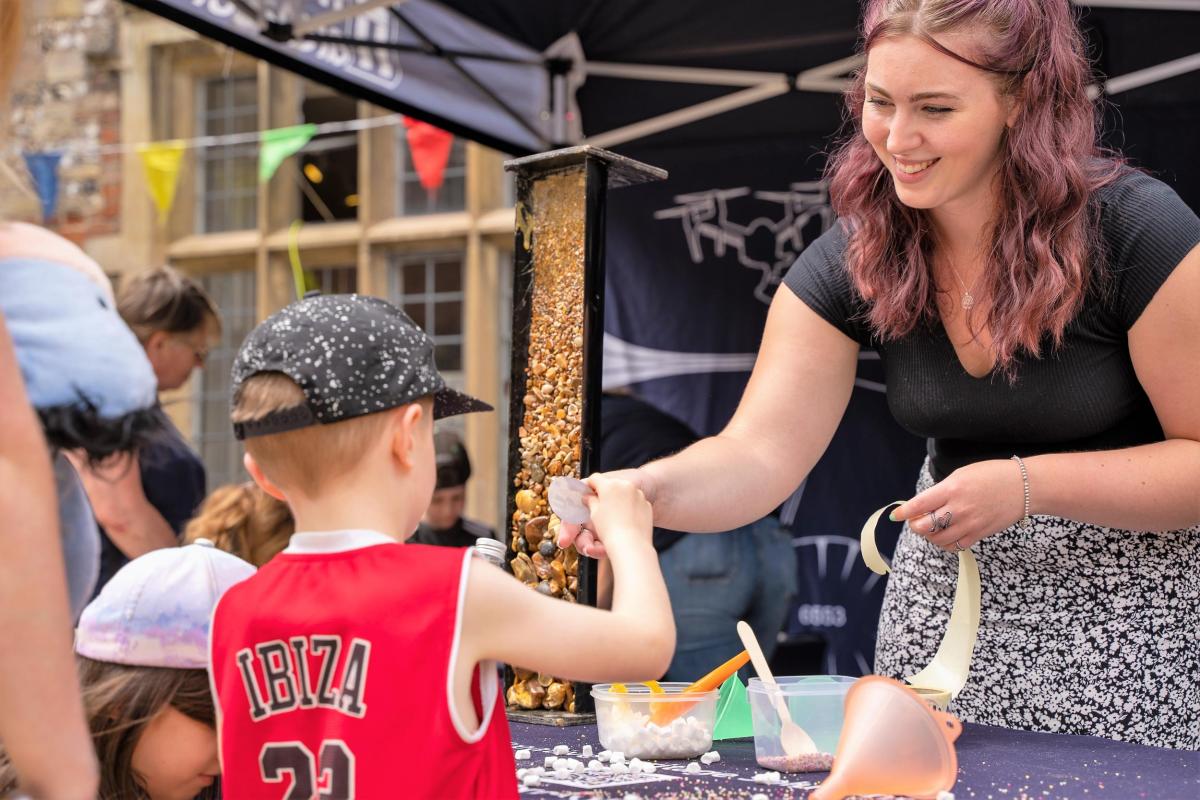 Rhiannon Piggon, Community Engagement specialist, assists a child in using a 3D Virtual Reality Experience