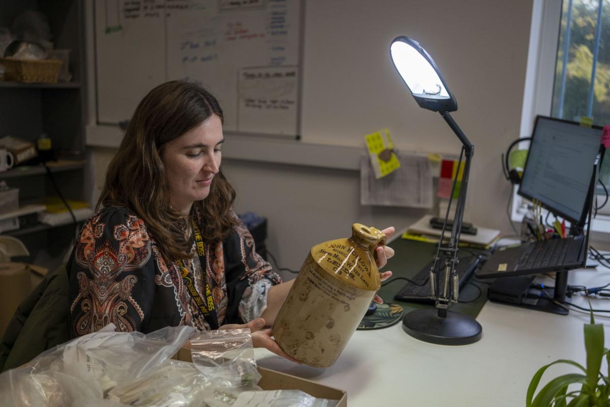 Jasmine looks at diagnostic indicators on a large stoneware jug