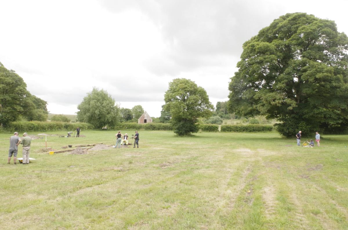 On a grassy field, archaeologists reveal historical remains just beneath the topsoil