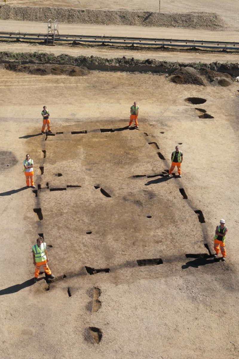 Archaeologists stand at the corners of the excavated Neolithic house at Horton