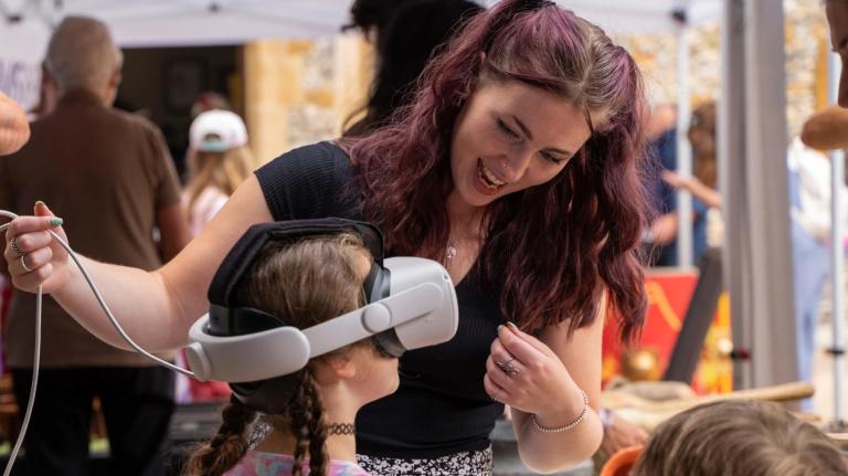 front cover of 23-25 impact report showing woman helping a child using a VR headset