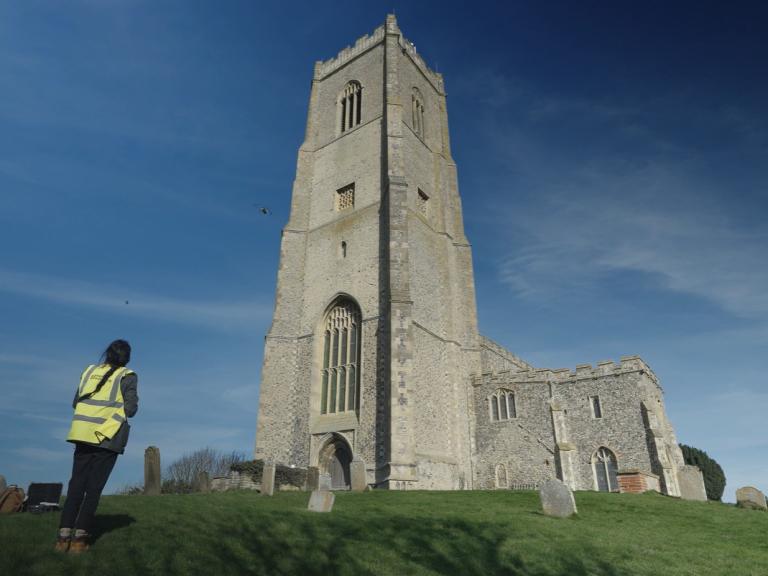 archeological survey expert undertakes drone survey of church, standing in churchyard