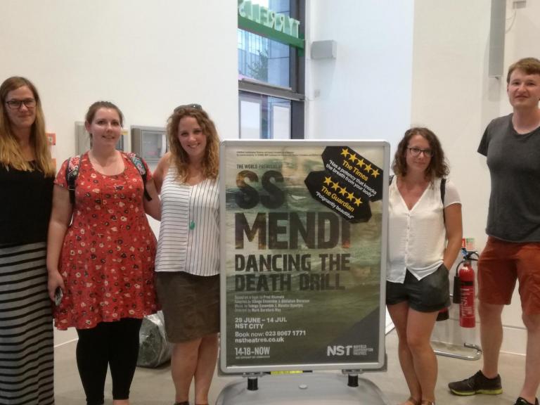 The group next to a SS Mendi: Dancing the Death Drill sign
