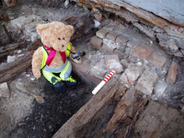 Kent Jones bear archaeologist taking photos on site