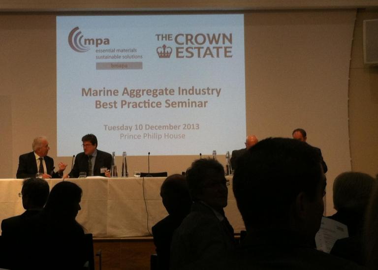 dark conference room with two men in suits in conversation 