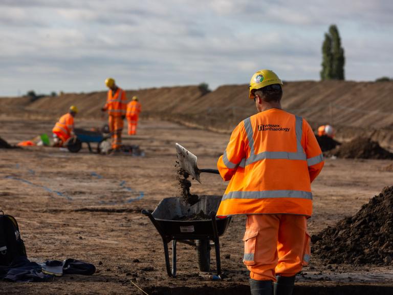 Viking Link Interconnector Archaeological work shows a large stripped area with archaeologist in hi vis and mounds of soil