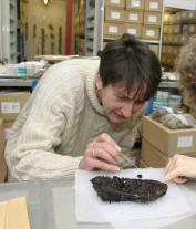 Jackie McKinley is shown inspecting an artefact.