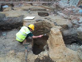 Medieval pit which cut through the lighter gravel of a Roman road at Fenchurch