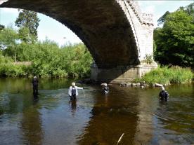 Richard of ADHS, Coralie of Dendrochronicle and Steph and Bob of Wessex Archaeology demonstrate the length and width of the stone platform under the 1784 Toll Bridge.