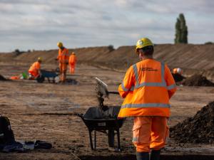 Viking Link Interconnector Archaeological work shows a large stripped area with archaeologist in hi vis and mounds of soil